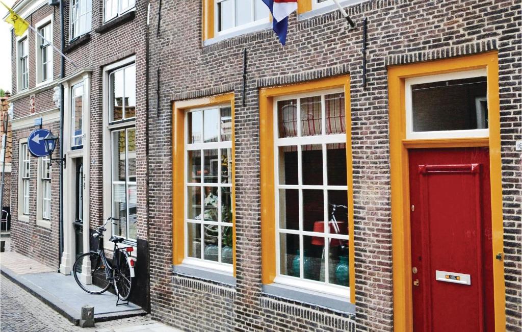 un edificio in mattoni con una porta rossa su una strada di Voc Huys a Enkhuizen