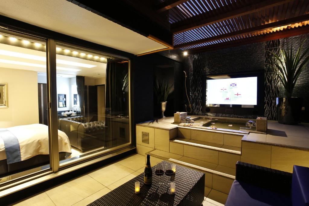 - une chambre avec une télévision, un lit et une baignoire dans l'établissement Hotel Moana Shinjuku (Adult Only), à Tokyo