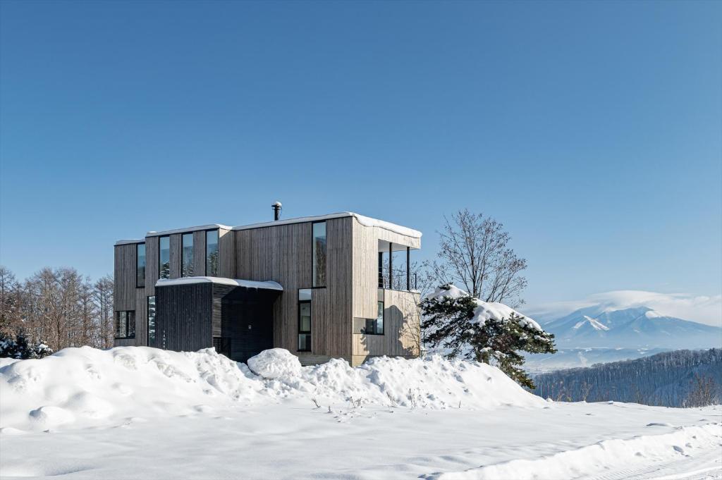 a building on top of a snow covered mountain at Yama no Oto in Furano