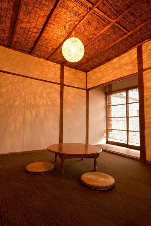 a room with a table in a room with a window at Grandma's House Kakurega in Kagoshima