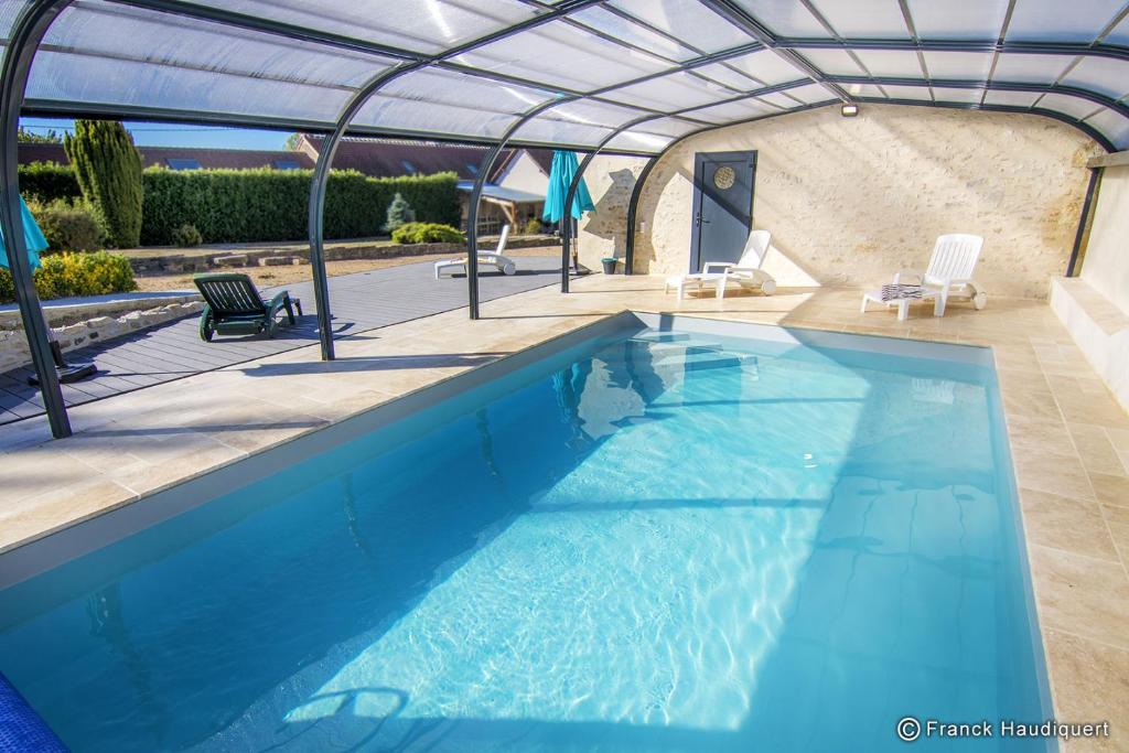 a swimming pool with a roof over it at Gite Domaine de Trevety in Châtillon-sur-Cher