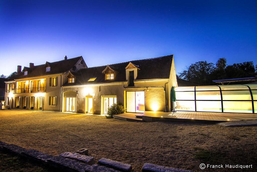Une grande maison éclairée la nuit dans l'établissement Gite Domaine de Trevety, à Châtillon-sur-Cher