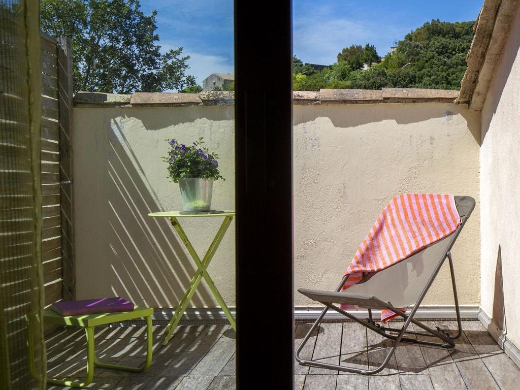 a chair and a table on a balcony at Le Clos des Chênes in Lagarde-Paréol