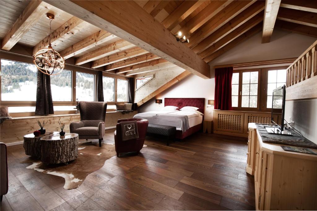 ein Schlafzimmer mit einem Bett und einem Schreibtisch in einem Zimmer in der Unterkunft Hotel Waldhaus am See in Valbella