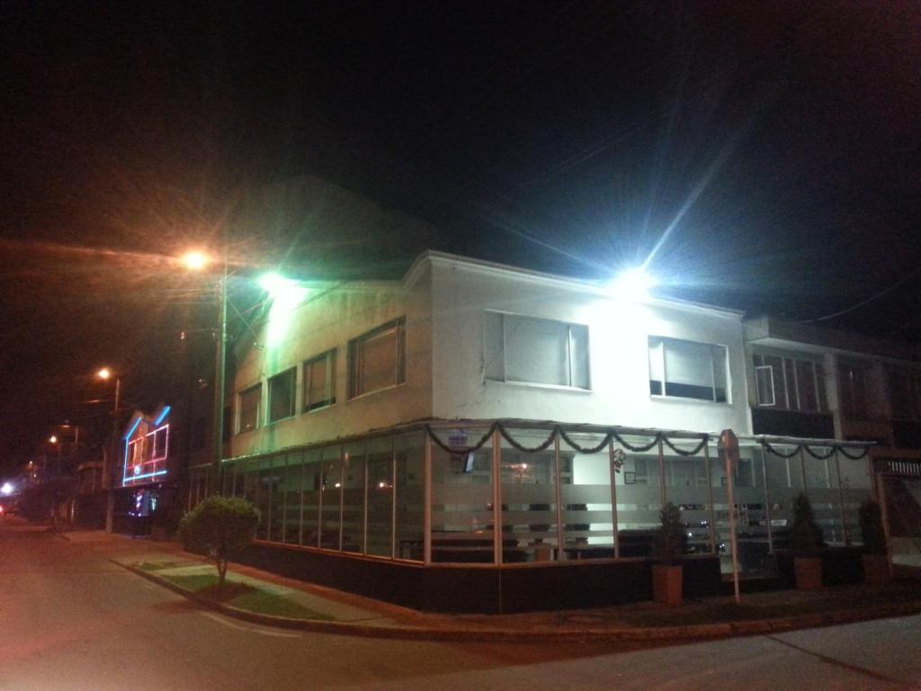 un bâtiment avec deux lumières au-dessus de celui-ci la nuit dans l'établissement Hotel Feria Nova, à Bogotá