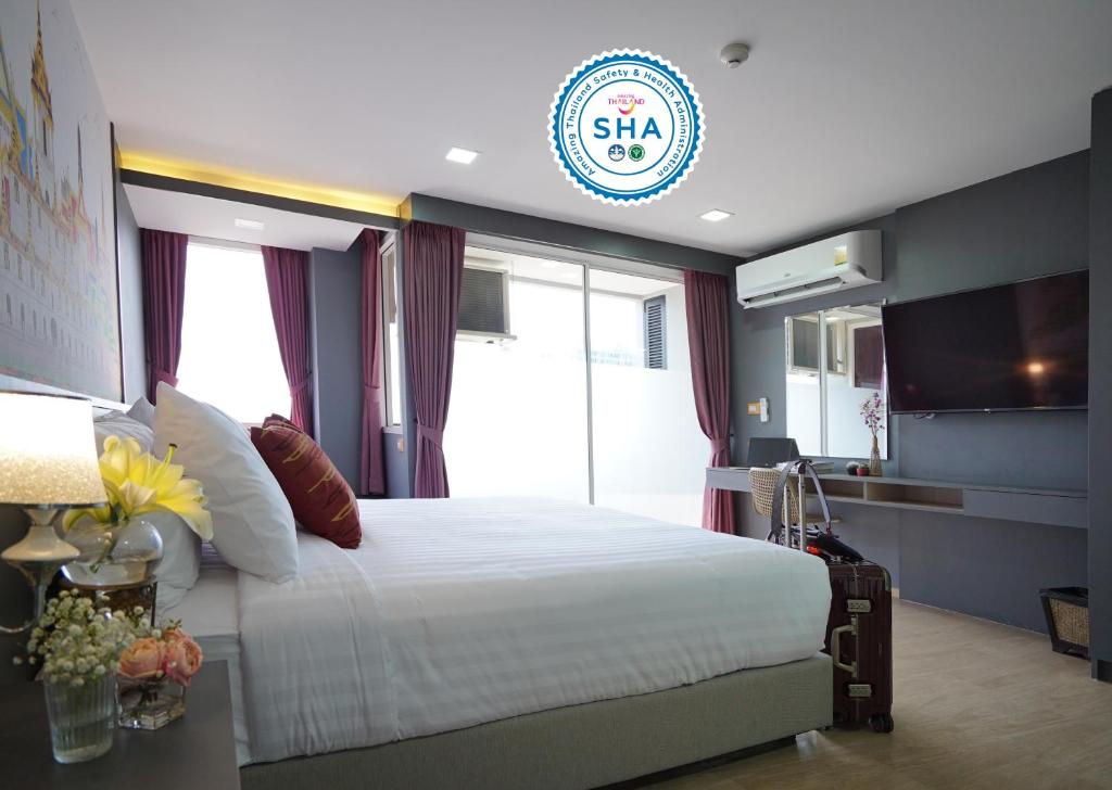 1 dormitorio con 1 cama grande y ventana grande en The Qube fifty Hotel, en Bangkok