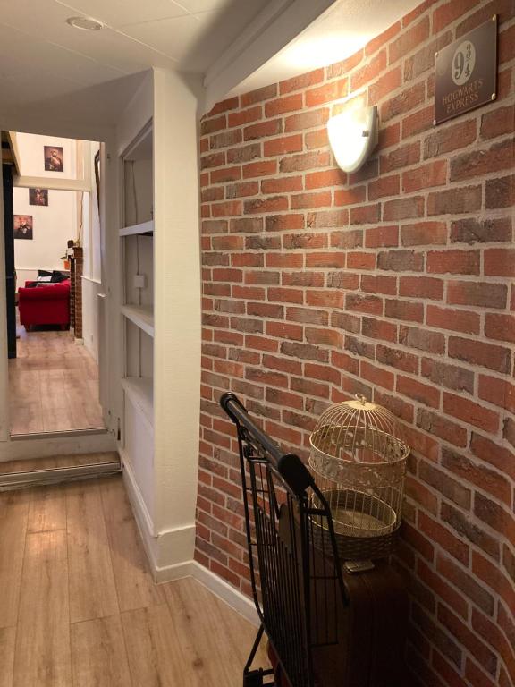 a room with a brick wall and a basket on a chair at Appartement magique des sorciers , centre historique Dijon in Dijon