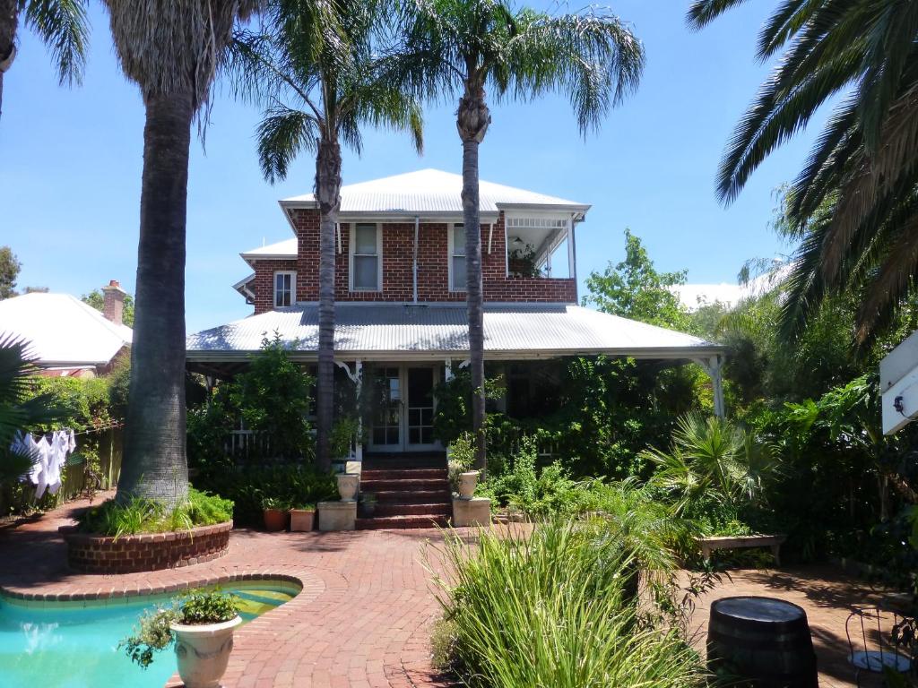 ein Haus mit Palmen und einem Pool in der Unterkunft Lakeside Bed & Breakfast in Perth
