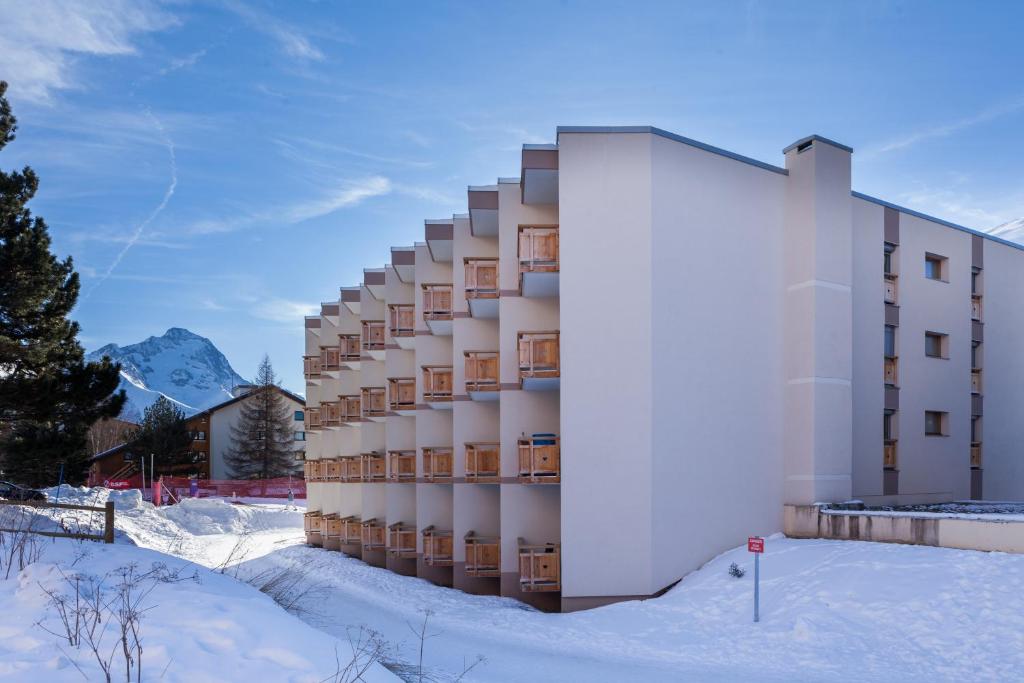 レ・デュー・アルプにあるVacancéole - Résidence Le Sappey - Les 2 Alpesの山前雪中の建物