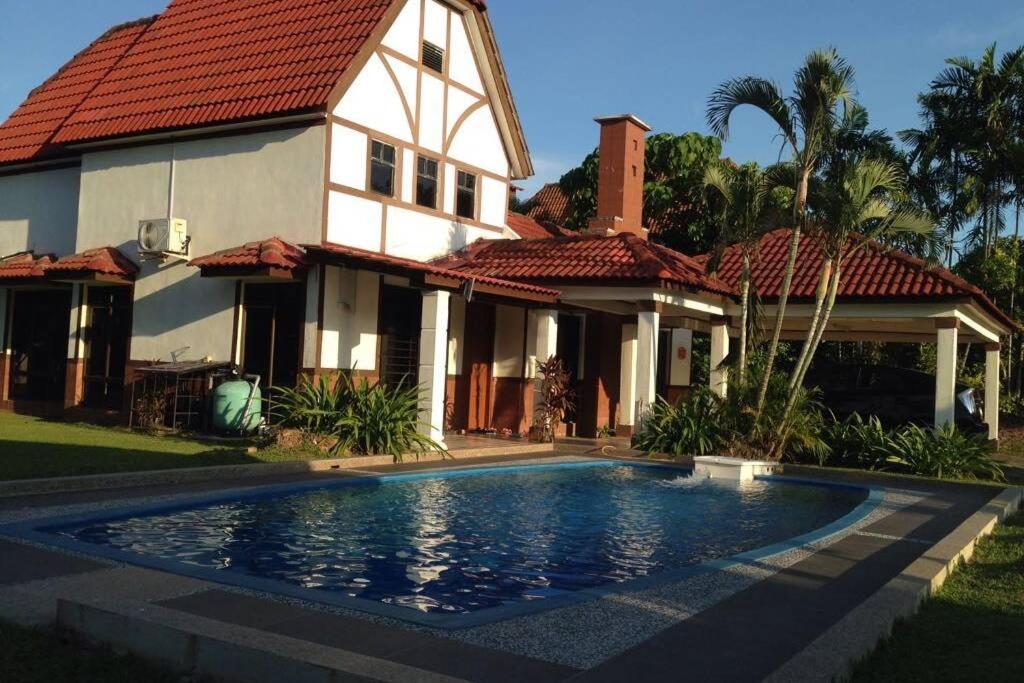 a house with a swimming pool in front of it at Villa Mommy A Famosa Resort in Melaka