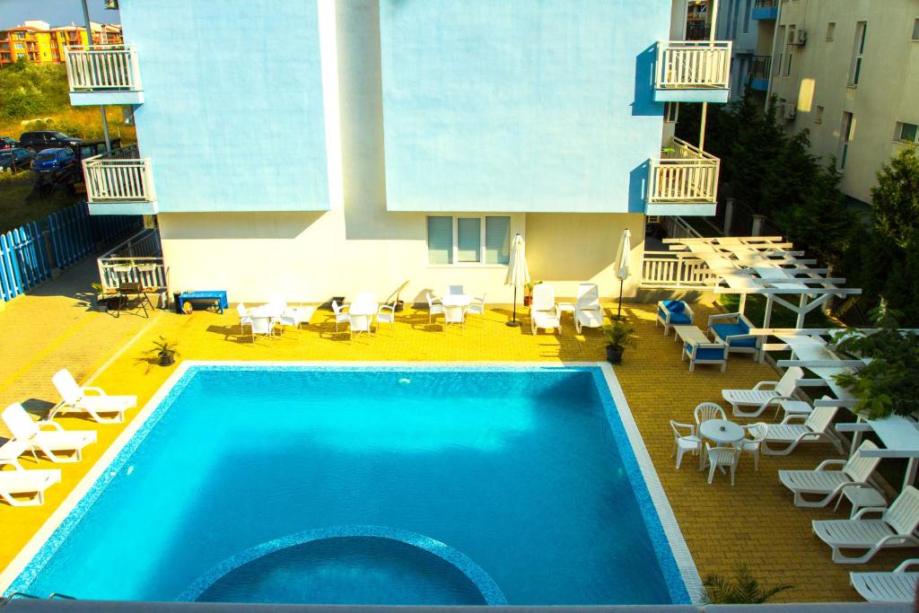 a swimming pool with chairs and tables and a building at Апартамент Lavander Fleur in Nesebar