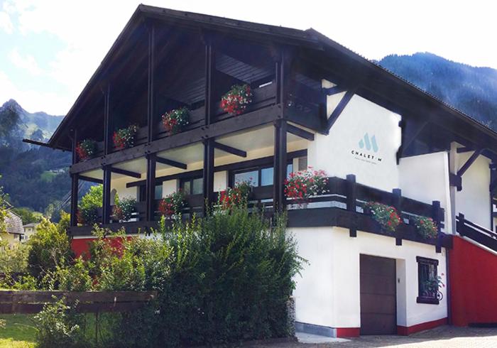 een gebouw met potplanten aan de zijkant bij Chalet M in Vandans