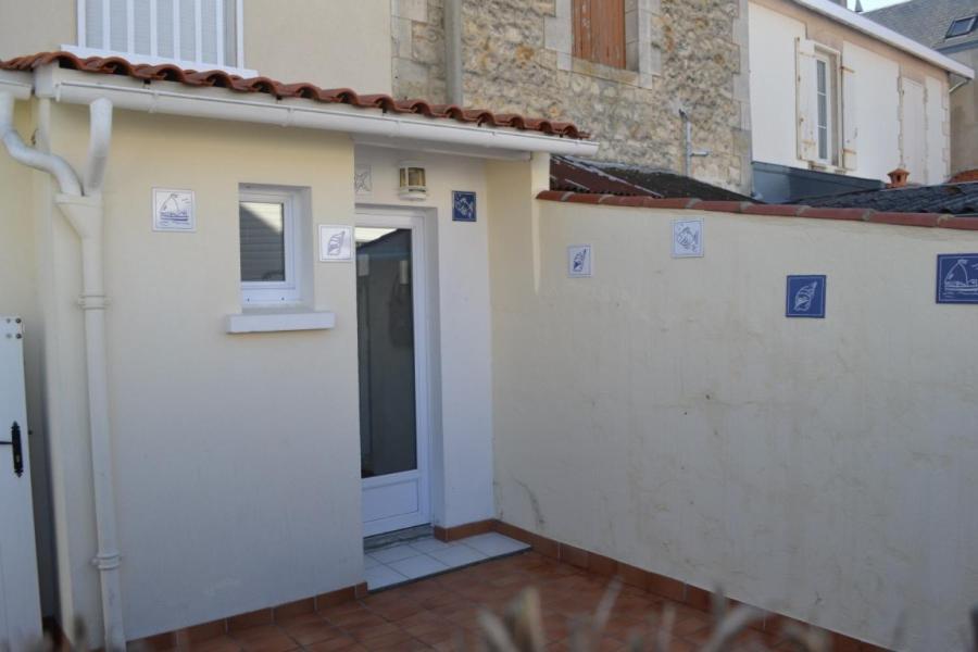 ein weißes Gebäude mit einer Tür und einem Fenster in der Unterkunft Maison 300 m de la plage in Châtelaillon-Plage