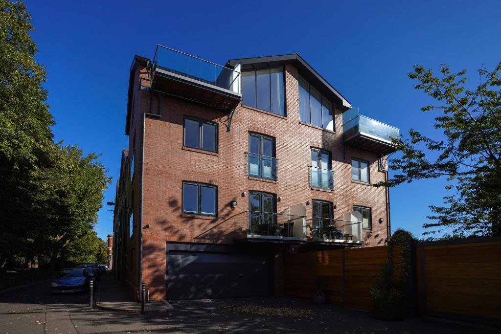 un edificio de ladrillo con balcón en la parte superior en Royal Stuart Lane - Townhouse by the Bay with Parking, en Cardiff