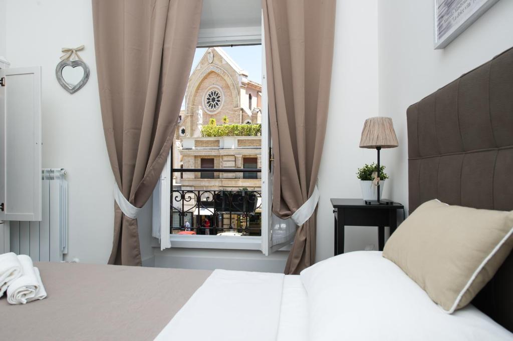 a bedroom with a white bed and a window at Rhoome Holiday in Rome