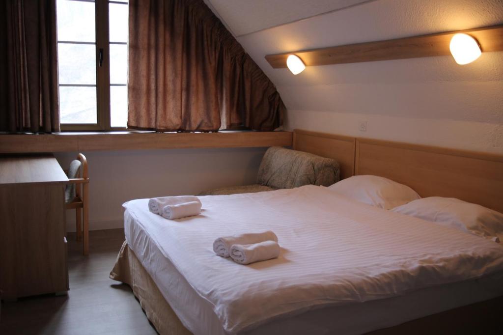 a bedroom with a bed with two towels on it at Hotel Fersped in Mavrovo