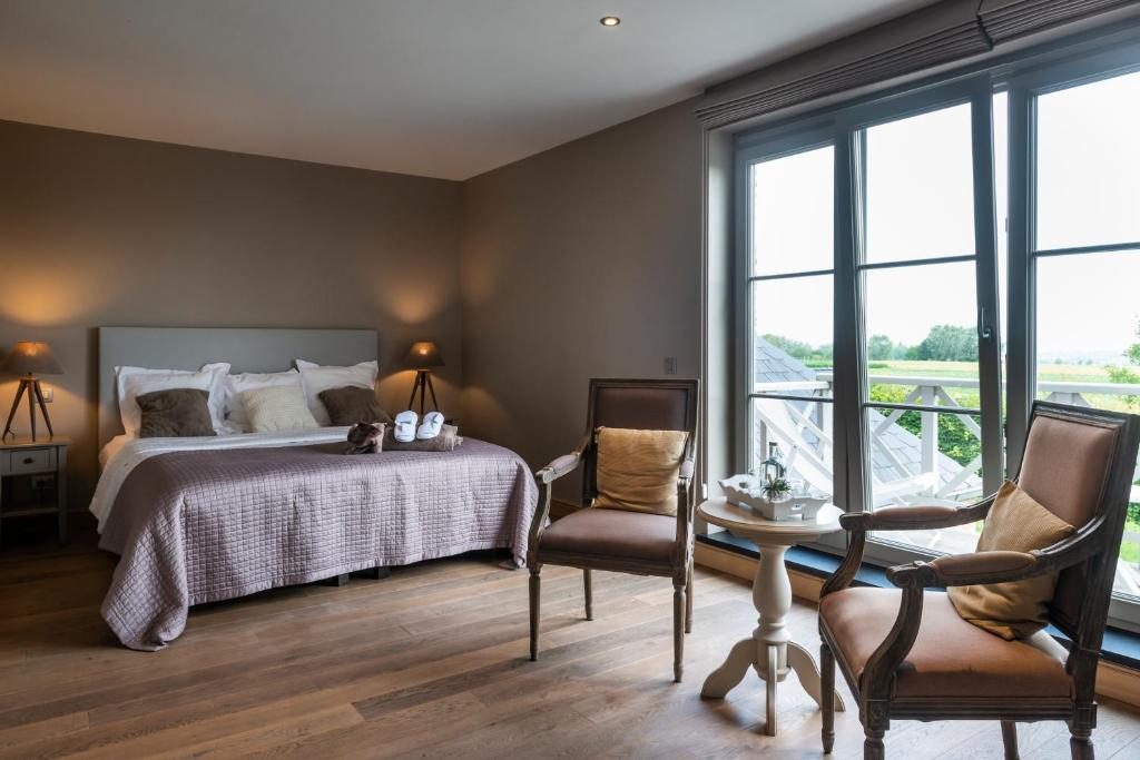 een slaapkamer met een bed en een tafel en stoelen bij B&B La Cereza in Oudenaarde