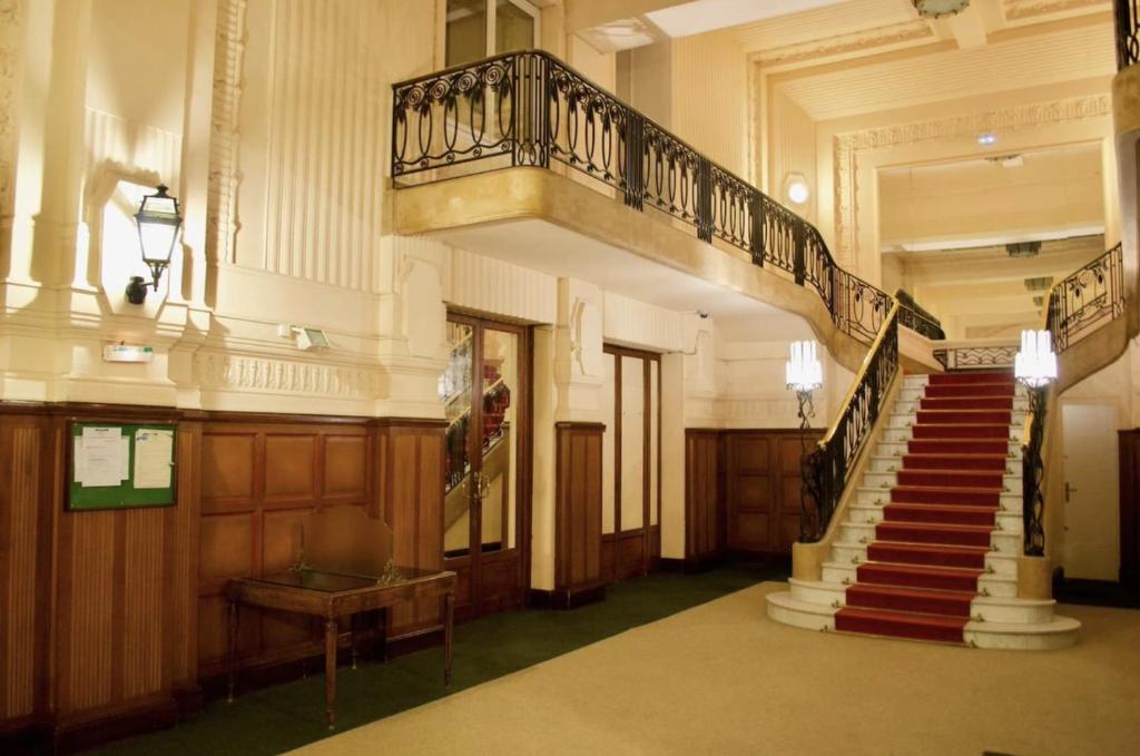 un couloir avec un escalier dans un immeuble dans l'établissement Appartement COEUR THERMAL proche Opéra, Casino, à Vichy
