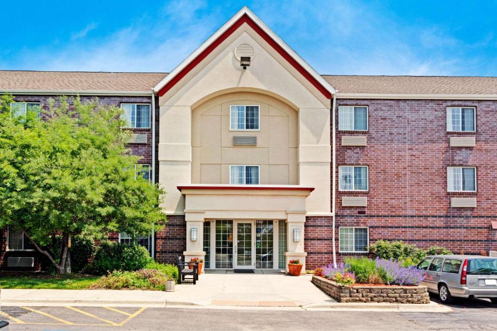 un edificio con un coche aparcado delante de él en MainStay Suites Chicago Hoffman Estates, en Hoffman Estates