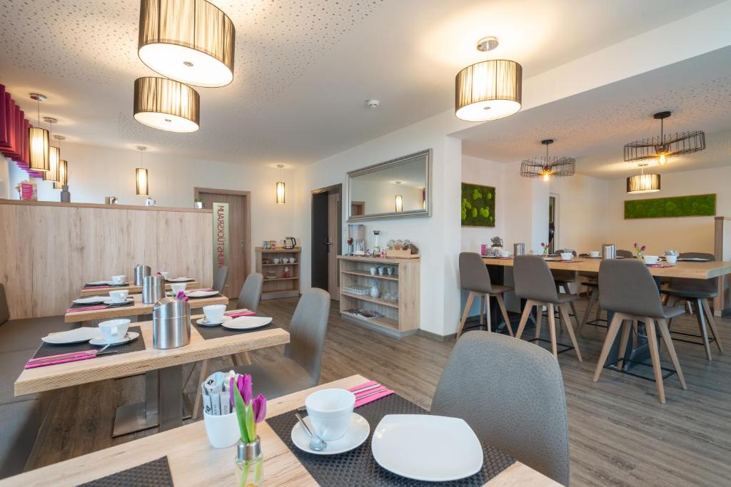 a restaurant with tables and chairs and a dining room at Leinotel in Leinefelde