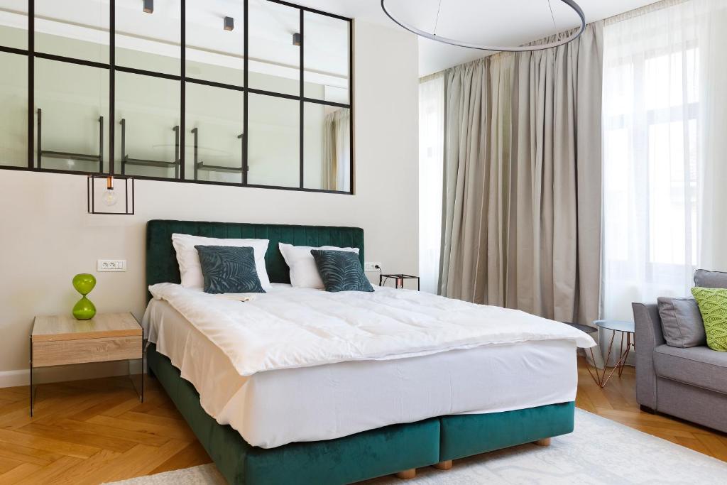a bedroom with a large bed with a green headboard at Postavarului8 in Braşov