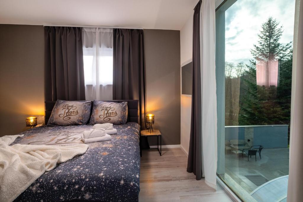 sypialnia z łóżkiem i dużym oknem w obiekcie Luxury Villa Rebecca w mieście Brestovac