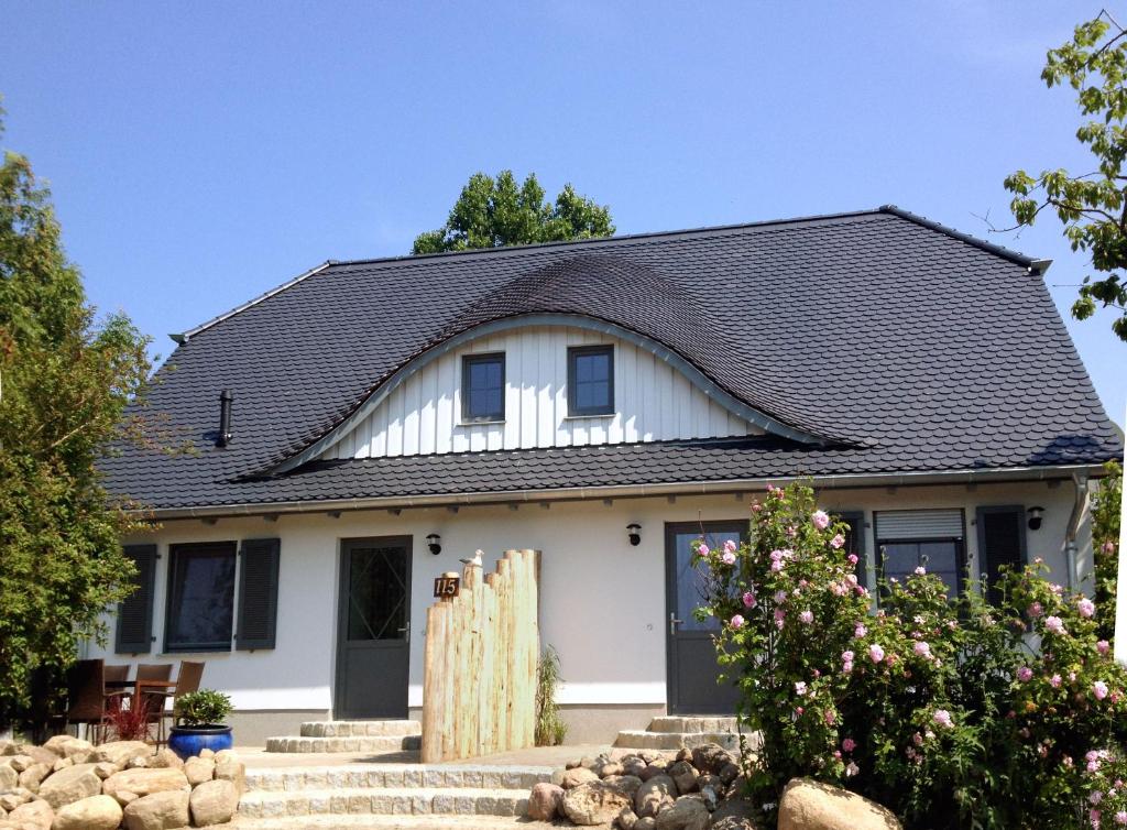 a white house with a black roof at Haus LEE in Kaltenhof