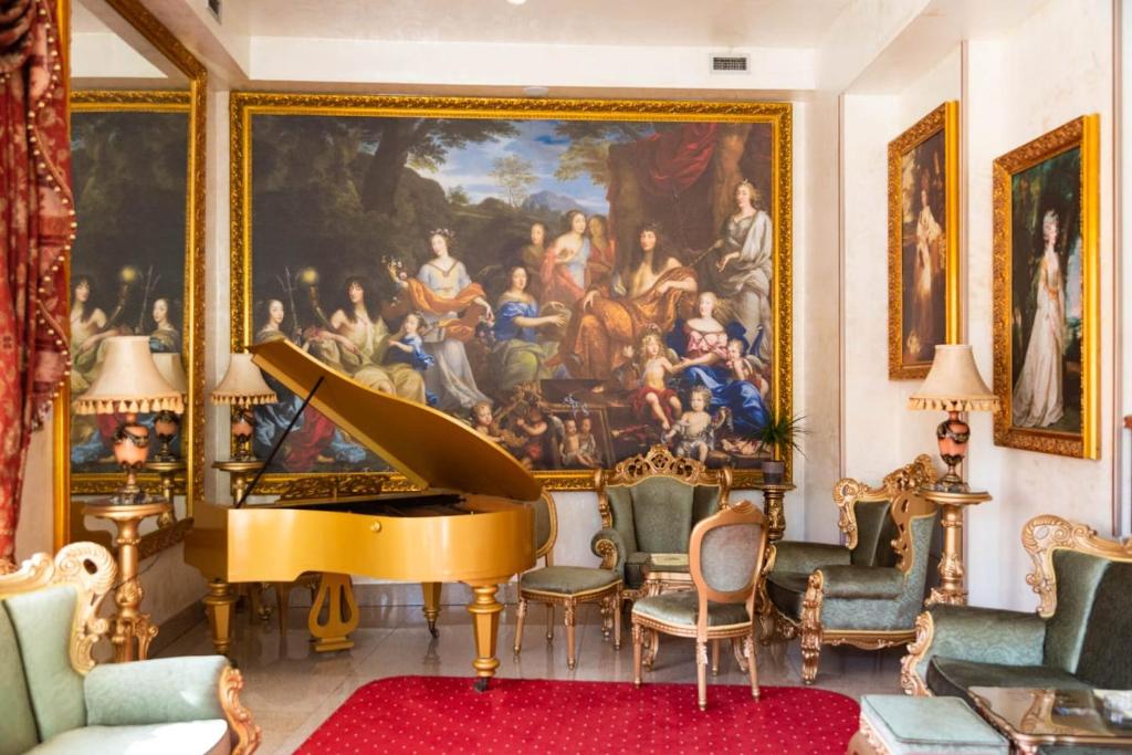 uma sala de estar com uma grande pintura e um piano de cauda em Premier Prezident Garni Hotel and Spa em Sremski Karlovci