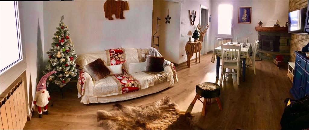 a living room with a christmas tree and a couch at la baita nei boschi in Serramazzoni
