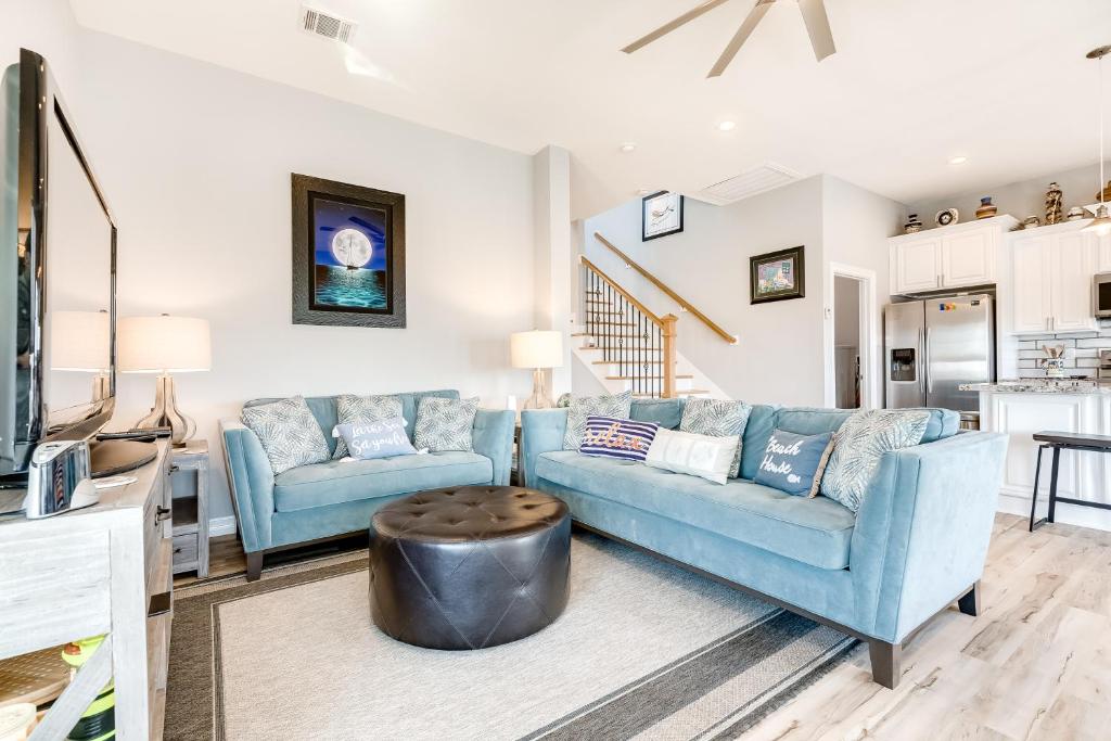 un salon avec deux canapés bleus et une table dans l'établissement Seahorse Beach House, à Galveston