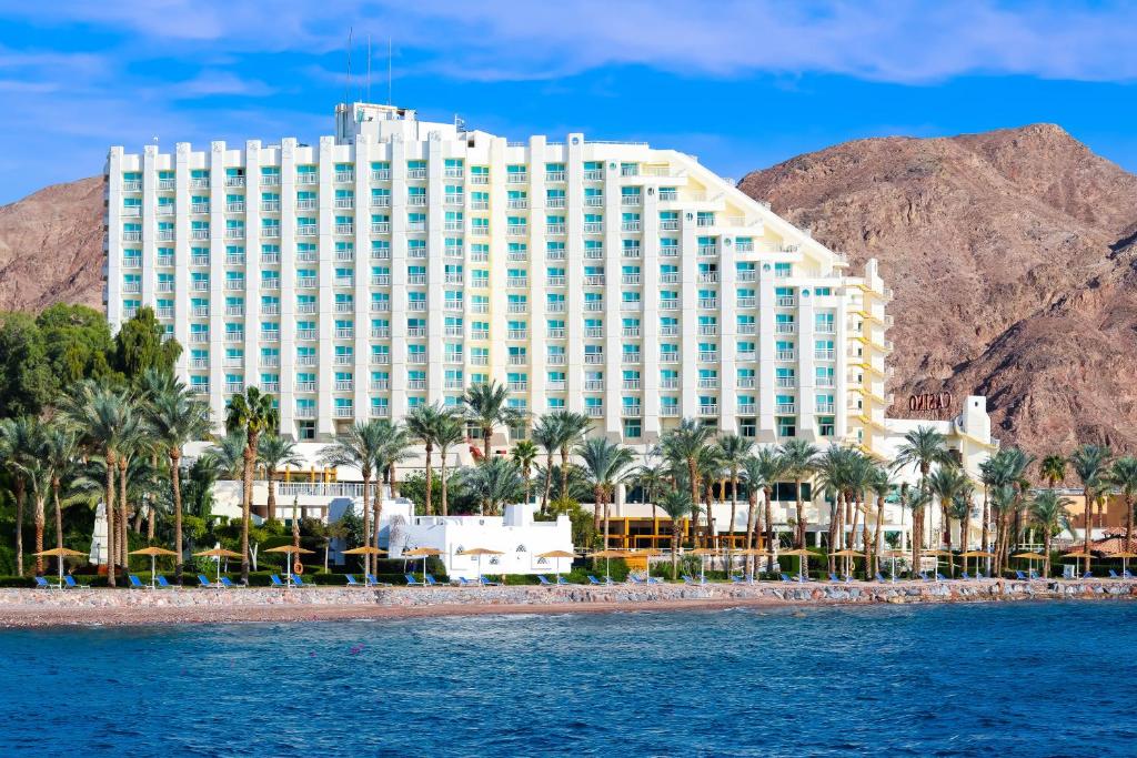 a hotel on the beach with a mountain in the background at Steigenberger Hotel & Nelson Village, Taba in Taba