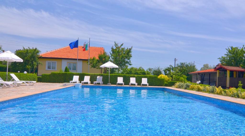 uma piscina com cadeiras e uma casa em Villa Amber em Bryastovets