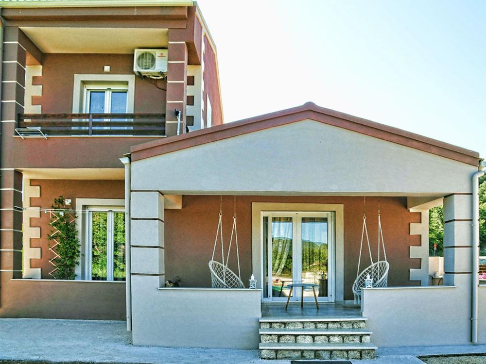 a building with a porch with a table and chairs at ANTIGONH COUNTRYSIDE VILLA !i in Kokkínion