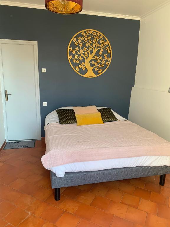 Schlafzimmer mit einem Bett mit Wandgemälde in der Unterkunft CHAMBRE D'HOTE in Gignac