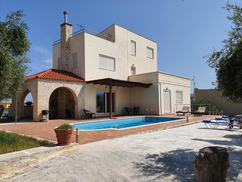 a house with a swimming pool in front of it at Argo Villa Kalives in Kalyves