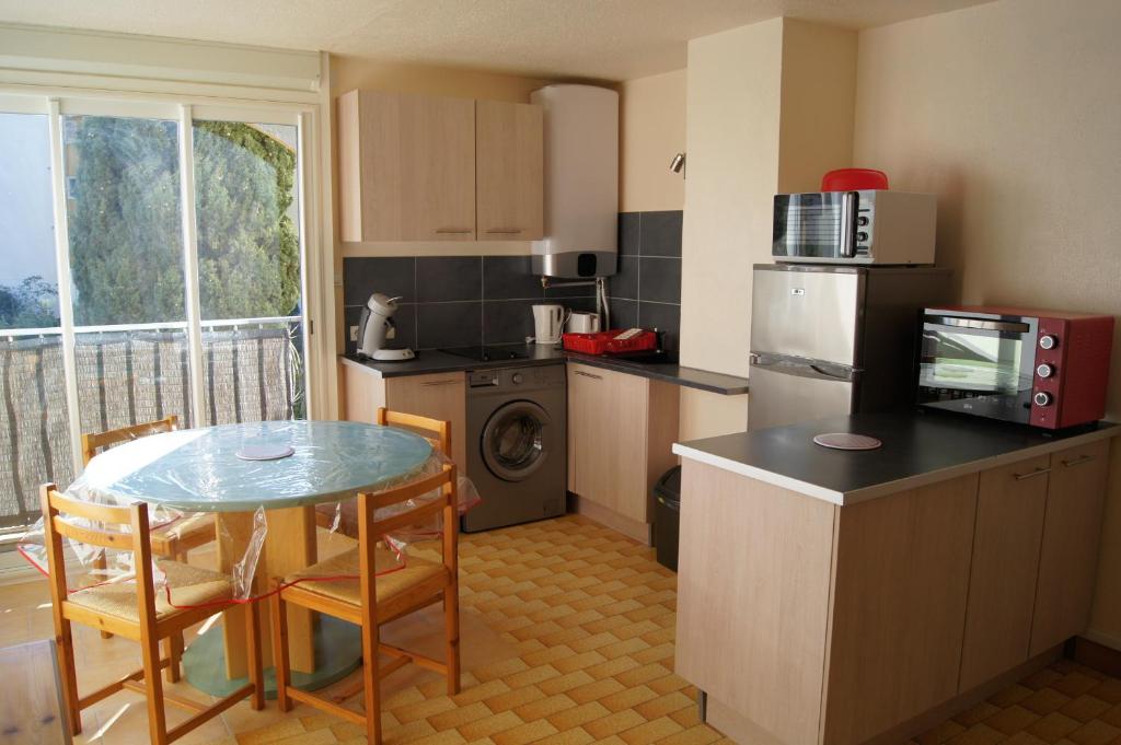 une cuisine avec une table, des chaises et un réfrigérateur dans l'établissement Lara 4 - T2 spacieux Parking - Près centre-port, île des Loisirs, plage Richelieu, au Cap d'Agde
