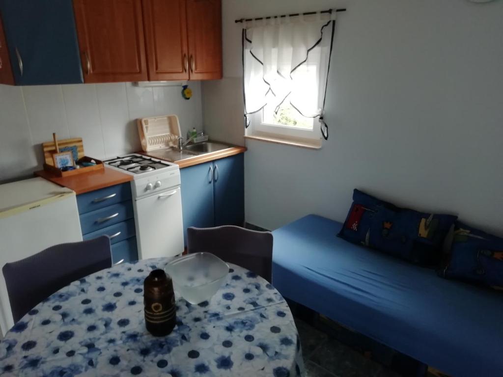 - une petite cuisine avec une table et un lit dans une chambre dans l'établissement Gordana Apartments, à Fažana