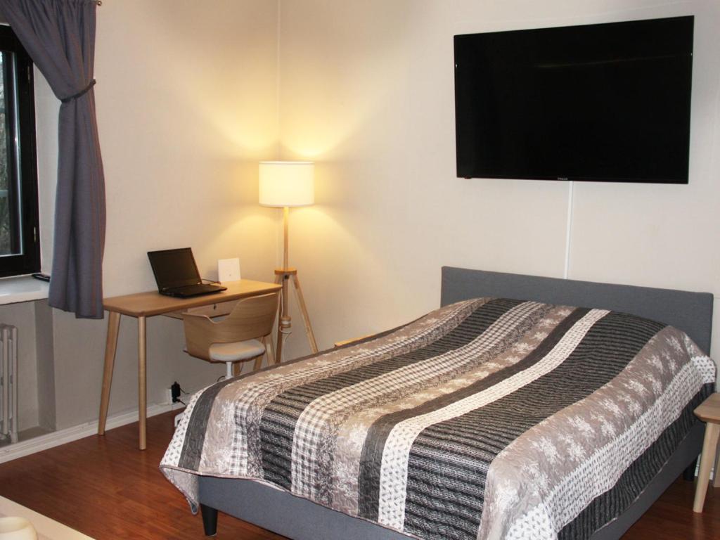 a bedroom with a bed and a desk with a laptop at Jokikatu kaksio in Turku