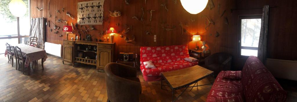 a living room with a red couch and a table at Boost Your Immo Chalet Vars 371 in Vars