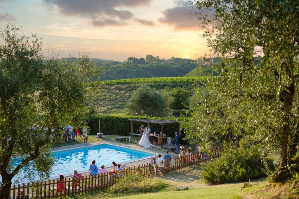 een groep mensen die rond een zwembad staan bij Villa Capanna in Siena