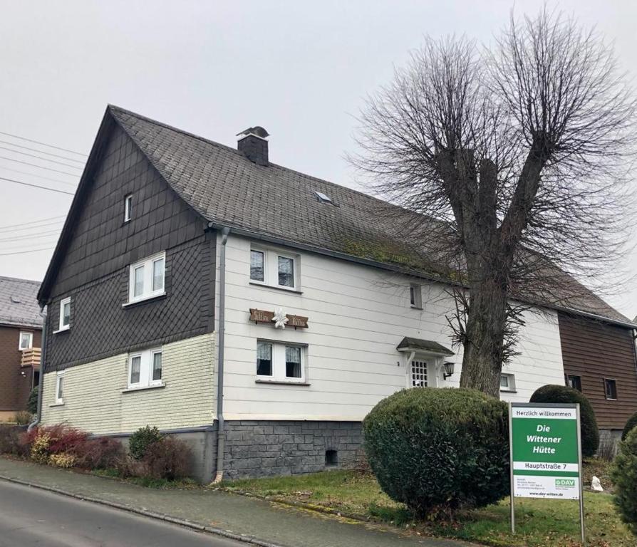 uma grande casa branca com um telhado preto em FEWO Wittener Hütte in Langenbach b.K. em Langenbach bei Kirburg