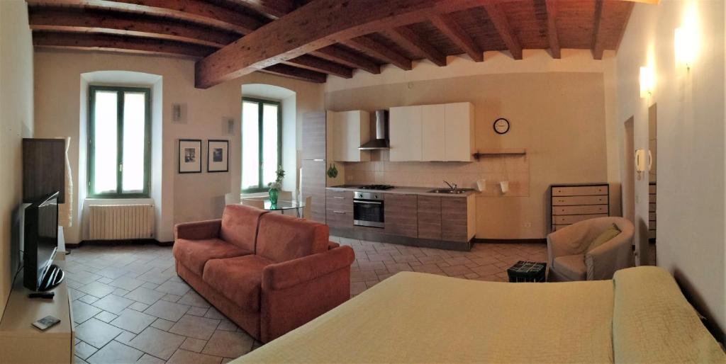 a living room with a couch and a kitchen at Soggiorno in Centro Storico in Vimercate