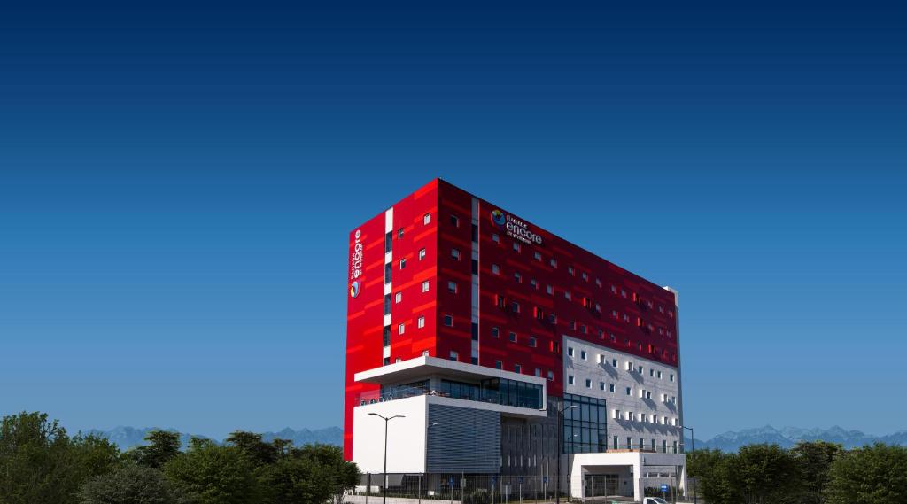 ein rotes Gebäude mit blauem Himmel im Hintergrund in der Unterkunft Ramada Encore by Wyndham Monterrey Apodaca Zona Aeropuerto in Monterrey