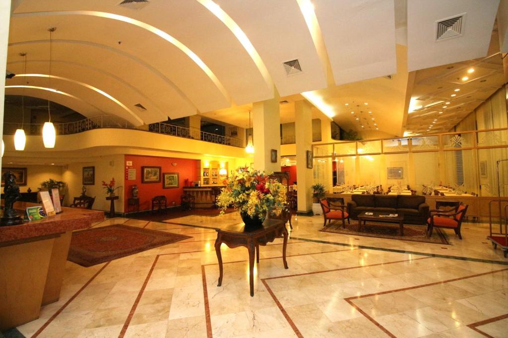 a lobby of a hotel with a table with flowers at Carlton Plaza São José dos Campos in São José dos Campos