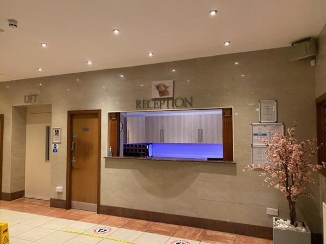 a reception area of a hospital with a television on the wall at West Park Hotel in Clydebank
