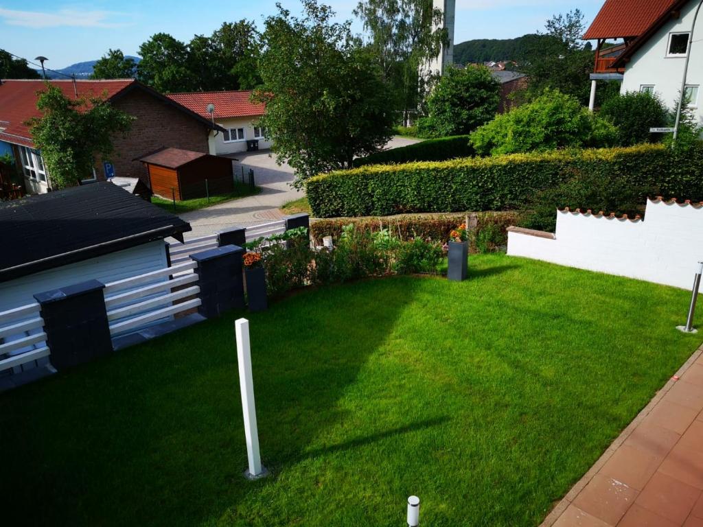 a yard with green grass and a white fence at Ferienwohnung Zur Waldkapelle in Nohfelden