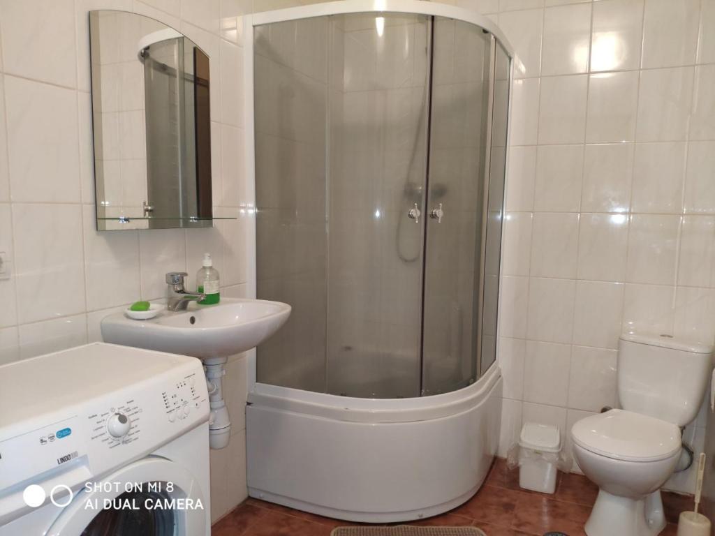 een badkamer met een douche, een wastafel en een toilet bij Apartments Domovik "Elegance" in Mukacheve