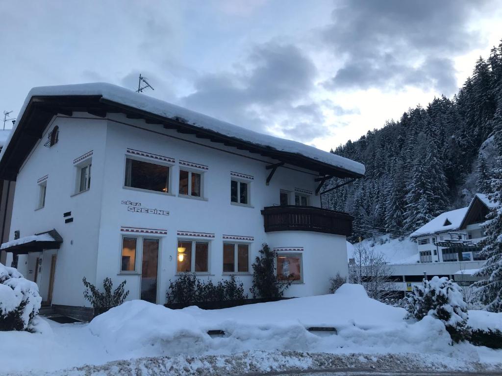 a white house with snow in front of it at Cësa Gredine in Ortisei