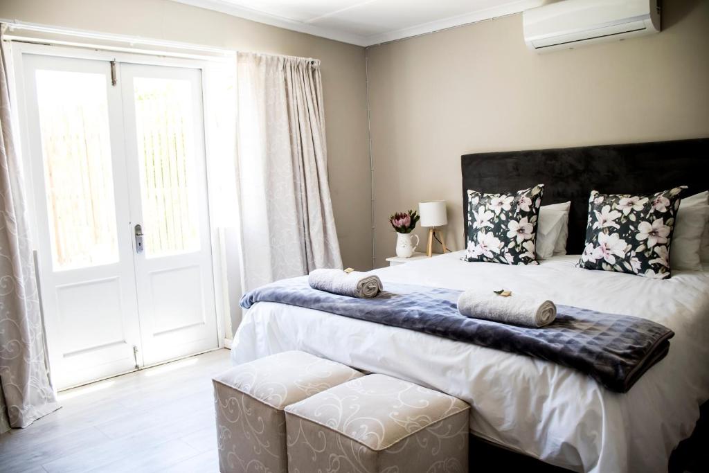 a bedroom with a large bed with a large window at The Grey House in Beaufort West