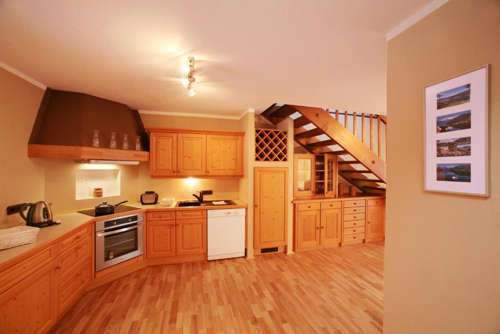 a kitchen with wooden cabinets and a staircase at Penthouse White Schmitten in Zell am See